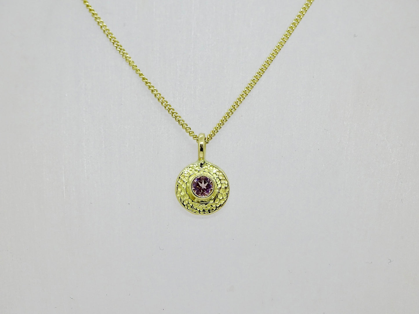 Gold disc with gem pendant