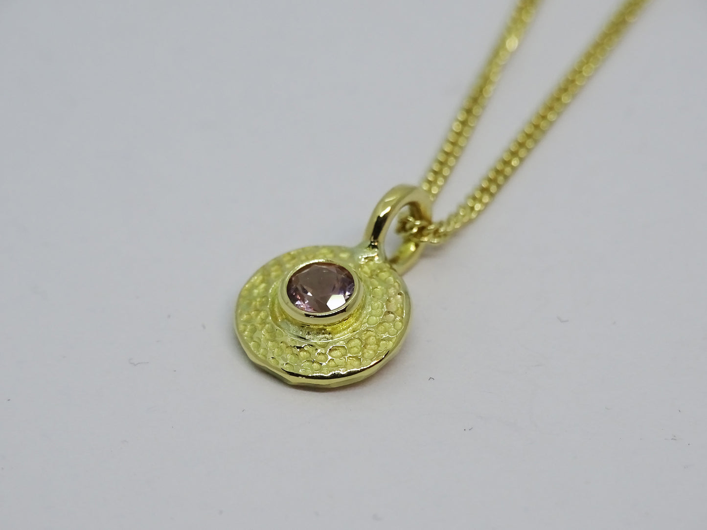 Gold disc with gem pendant